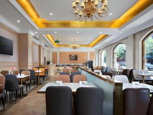 a restaurant with tables and chairs and a chandelier at Vienna Hotel Guangzhou Yonghe Development Zone in Guangzhou