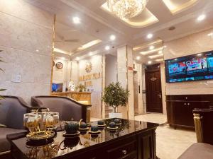 a living room with a table and a television at Majestik Hanoi Hotel in Hanoi
