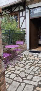 Ein lila Tisch und Stühle auf einer Steinterrasse in der Unterkunft Studio propre disponible in Vigneux-sur-Seine