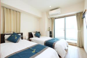 a hotel room with two beds and a window at 中央公馆 Central Mansions 地下鉄谷町六丁目徒步1分心斎橋駅天王寺駅まで電車1本 in Osaka