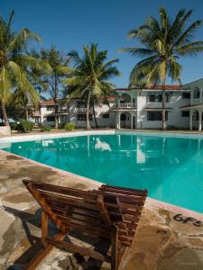 a bench sitting in front of a swimming pool at Bahari Dhow Beach Villas in Diani Beach
