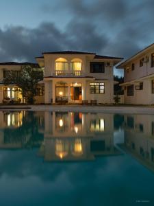 a house with a pool of water in front of it at Bahari Dhow Beach Villas in Diani Beach +30 photos