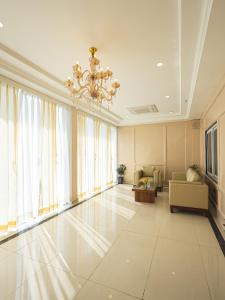 ein großes Wohnzimmer mit einem Kronleuchter in der Unterkunft Saswata Hotels By Kamay Group in Ayodhya