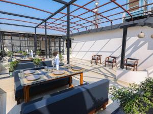 eine Terrasse mit Tischen und Stühlen auf einem Gebäude in der Unterkunft Saswata Hotels By Kamay Group in Ayodhya
