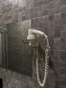 Un secador de pelo en la pared de un baño. en Hotel DoZari, en Korostyshiv