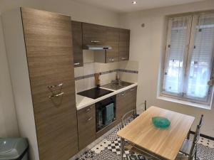 a kitchen with wooden cabinets and a wooden table at Budget Studio avec Parking in Charleville-Mézières