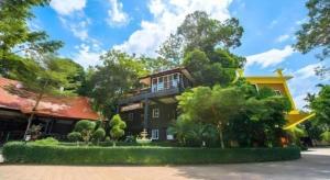 ein großes Haus mit Bäumen davor in der Unterkunft Phutara Resort in Ban Bang Non Nai