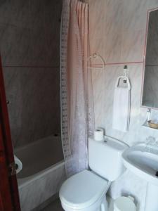a bathroom with a toilet and a tub and a sink at Hostal la Campa in Chiclana de la Frontera