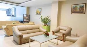 ein Wohnzimmer mit Sofas und einem Tisch im Zimmer in der Unterkunft dPalma Hotel in Bandung