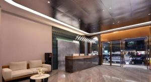 a lobby with a couch and a table in a building at Jinjiang Inn Haikou Jinjiuling Park Branch in Haikou