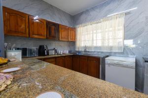 eine Küche mit Holzschränken und einer Marmoroberfläche in der Unterkunft Seagull Apartment -2 Bedroom Apartment 408 by First Private Stays in Margate