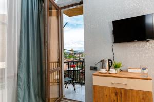a room with a view of a balcony with a television at Golden Pheasant in Tbilisi City