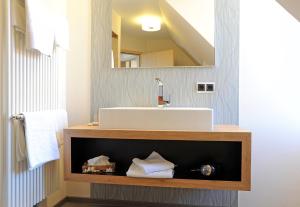 La salle de bains est pourvue d'un lavabo et d'un miroir. dans l'établissement Landgasthof Zum Schwarzen Adler, à Markt Nordheim