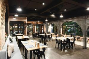 ein Restaurant mit Tischen und Stühlen in einem Raum in der Unterkunft Verona Boutique Hotel - The Verona Co., Ltd in Ban Wang Khon Daeng