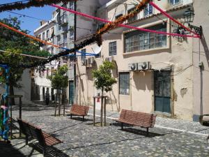 un grupo de bancos en una calle frente a un edificio en Apartment Jasmim, en Lisboa