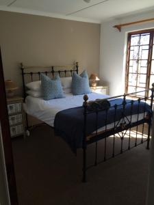 RomansrivierMosterts Hoek Guest House的卧室里有一张床，上面有蓝白色的枕头