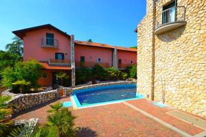 a house with a swimming pool next to a building at Holiday Homes in Lignano 21665 in Lignano Sabbiadoro +2 photos