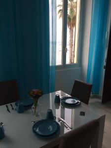 a table with blue plates on it with a view of the beach at Casa al Prino in Imperia