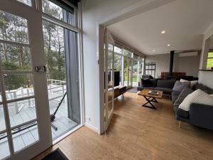 een woonkamer met een bank en een tafel bij Sunset View House in Warburton