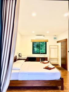 een slaapkamer met twee bedden en een raam bij Serenia Garden Resort in Ko Lanta Yai