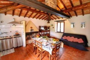 ein Wohnzimmer mit einem Tisch und einer Küche in der Unterkunft Agriturismo Bellavista in Radicondoli