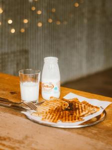 a plate of waffles and a bottle of milk on a table at Hotel King Plaza in New Delhi
