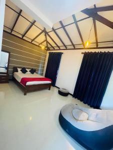 een slaapkamer met een bed en een bank erin bij Woori House in Kamburugamuwa