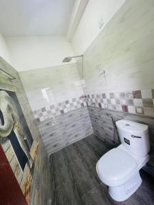 een badkamer met een wit toilet in een kamer bij Woori House in Kamburugamuwa