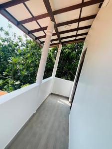 een balkon van een huis met een houten dak bij Woori House in Kamburugamuwa +5 foto's
