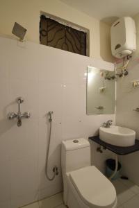 Un baño blanco con inodoro y lavabo. en Hotel Krishna Palace, en Udaipur