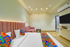 a hotel room with a bed and a flat screen tv at FabHotel Morya Regency - Bhopal railway station platform no 6 in Bhopal