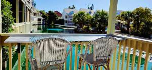 2 Stühle auf einem Balkon mit Flussblick in der Unterkunft Fairyhouse on the Lake - Resort with Pool and Lake in Heart of Mandurah in Mandurah