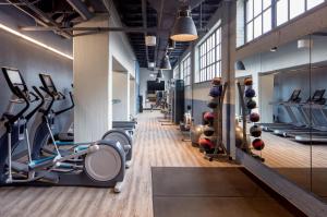 a gym with treadmills and exercise equipment on the walls at Holston House Nashville, in The Unbound Collection by Hyatt in Nashville