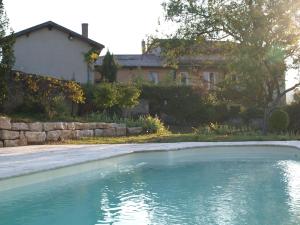 une piscine d'eau en face d'une maison dans l'établissement Le Vallon des Ronzières, à Gleizé