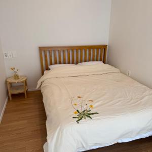 ein weißes Bett mit Blumenarrangement darauf in der Unterkunft House Taehwa Hanok Stay in Andong + 39 Fotos