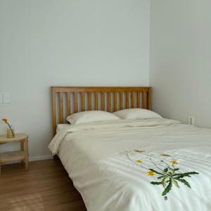 um quarto com uma grande cama branca com flores em House Taehwa Hanok Stay em Andong