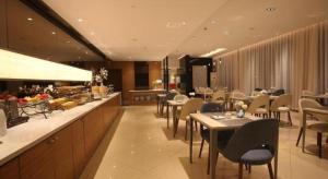 a restaurant with tables and chairs and a counter at Magnotel Business Xuzhou Jinying Sudi Road Metro Station in Xuzhou