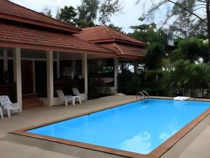 ein großer blauer Swimmingpool vor einem Haus in der Unterkunft Chaya Resort in Ao Nang Beach
