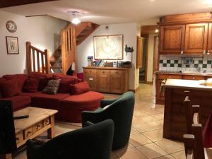 Una sala de estar con un sofá rojo y una cocina. en Time to Ski - Piaf, en Sainte-Foy-Tarentaise