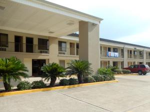 a hotel with palm trees in a parking lot at Motel 6-Luling, LA in Luling