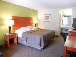 um quarto de hotel com uma cama e uma televisão em Motel 6-Luling, LA em Luling