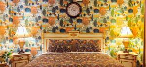 ein Schlafzimmer mit einem Bett mit zwei Lampen und einer Uhr in der Unterkunft Fairyhouse on the Lake - Resort with Pool and Lake in Heart of Mandurah in Mandurah