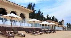 a row of chairs with umbrellas in front of a building at Hainan Yatai Hot Spring Hotel in Haikou