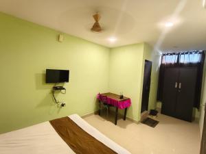 a room with a table and a tv on the wall at THE METRO INTERNATIONAL HOTEL in Hyderabad
