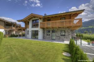 une maison avec une terrasse au-dessus d'une cour dans l'établissement Deer & Dear Luxury Chalet, à Piesendorf