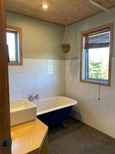 a bathroom with a large tub and a window at Stony Ridge Summer Stay in Motueka