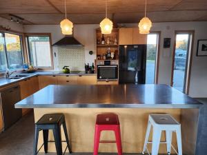 a kitchen with a large counter with two stools at Stony Ridge Summer Stay in Motueka +10 photos