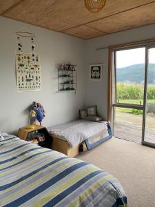 a bedroom with a bed and a sliding glass door at Stony Ridge Summer Stay in Motueka