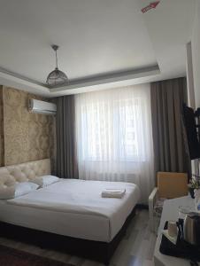 ein Schlafzimmer mit einem weißen Bett und einem Fenster in der Unterkunft Hotel seven park in Nevşehir