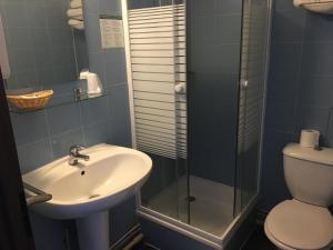 a bathroom with a sink and a shower and a toilet at Nouveau Paris Park Hotel in Paris